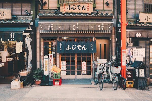 Traditional Japanese shopfront with hanging noren curtains and bicycles parked outside