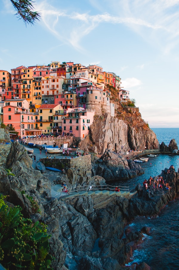 Brightly painted houses stacked on a cliff above the sea